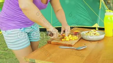 年轻女子在野餐时用刀子切<strong>一把</strong>桃刀做水果沙拉。